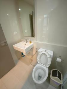 a bathroom with a white toilet and a sink at The Base in pattaya in Pattaya Central