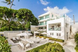 una casa blanca con sillas y sombrillas blancas en Footprints by Blue Sky Luxury, en Saint James