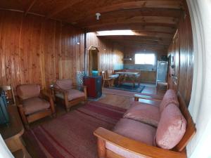 vistas panorámicas a una sala de estar con sofá y sillas en Cabañas Rayen Karu, en Puerto Montt
