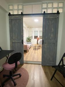 an open door in a room with a chair and a table at Bonito piso cerca de Ventas, Madrid in Madrid