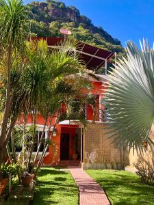 a red house with palm trees in front of it at Casa de Alondras in Panajachel