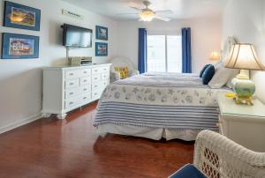 1 dormitorio con 1 cama con cómoda y TV en Sands II 1-J, en Carolina Beach