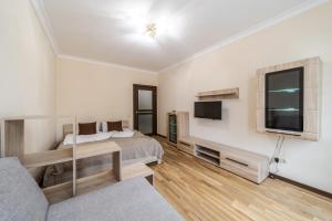 a bedroom with a bed and a flat screen tv at InshiApartment on Kulisha str 2 in Lviv