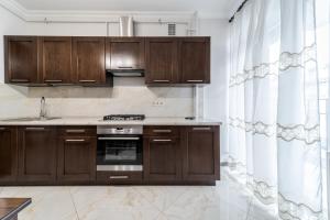 a kitchen with wooden cabinets and a stove top oven at InshiApartment on Kulisha str 2 in Lviv