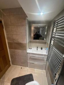 uma pessoa a tirar uma fotografia num espelho de casa de banho em 2 bedroom apartment in HampdenRd em Londres