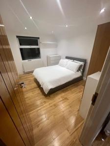 Habitación pequeña con cama y ventana en 2 bedroom apartment in HampdenRd, en Londres