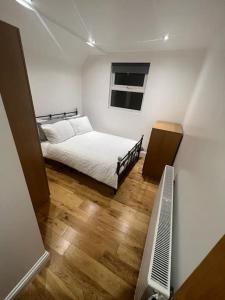 Habitación blanca con cama y ventana en 2 bedroom apartment in HampdenRd, en Londres