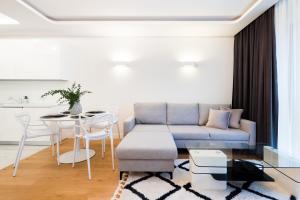 a living room with a blue couch and a table at Wilanów Dream & Heaven Apartments in Warsaw