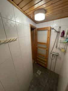 baño pequeño con ducha y puerta en Stylish 2 bedroom city apartment, en Rovaniemi
