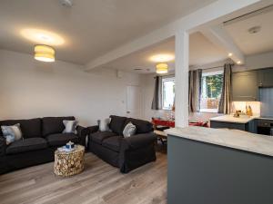 a living room with two couches and a kitchen at Shorelands in Wadebridge