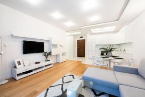 a living room with a blue couch and a tv at Wilanów Dream & Heaven Apartments in Warsaw