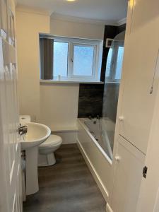 a bathroom with a sink and a toilet and a bath tub at Rhyl beach town apartment in Rhyl