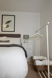 een witte slaapkamer met een bed en een lamp bij Modern Luxurious Apartment in Birmingham