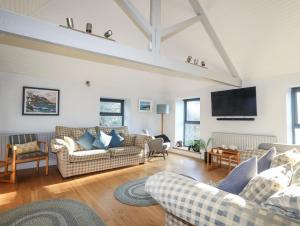 a living room with couches and a flat screen tv at Plas Elyn in Beaumaris