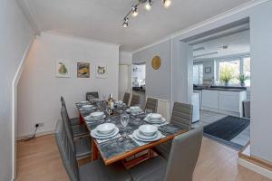 a dining room and living room with a table and chairs at Ger y Bae sleeps 12 in Cemaes Bay
