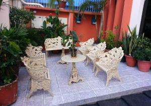 a patio with a table and chairs and plants at Hotel Paraiso Belém in Belém