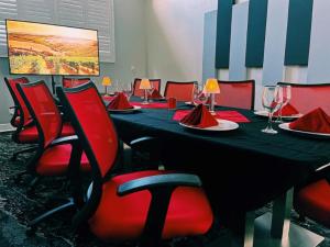 a conference room with a long table and red chairs at Wyvern Hotel, Ascend Hotel Collection in Punta Gorda