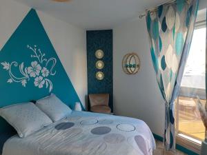 a bedroom with a bed with a blue head board at Appart hyper centre- Parking in Vierzon