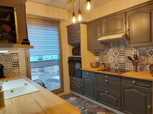 a kitchen with gray cabinets and a sink and a window at Appart hyper centre- Parking in Vierzon