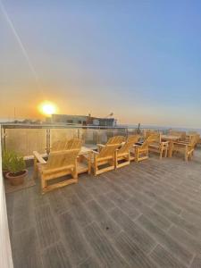 a row of wooden chairs sitting on top of a roof at Ayour Beach House 1 in Imsouane