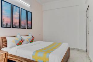 a white bedroom with a bed and some windows at OYO Home Dazzling Studios Near Airport Near Pune Airport in Lohogaon