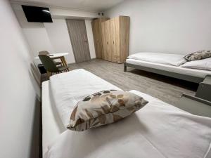 a bedroom with two beds and a tv on a wall at Hostel H18 in Bardejov