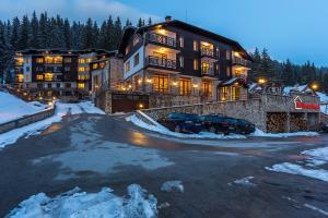 a large building with a parking lot in the snow at апартамент Крис 513 Stream tesort in Pamporovo
