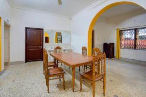 a dining room with a wooden table and chairs at OYO Home Jaam's Home Stay in Bhubaneshwar