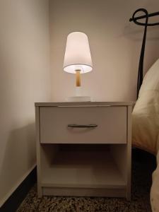 una mesa con una lámpara junto a una cama en Tyrrenium Salerno, en Salerno