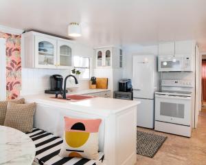 eine Küche mit weißen Schränken und einer Arbeitsplatte in der Unterkunft Baby Owl Lakehouse in Canyon Lake + 9 Fotos