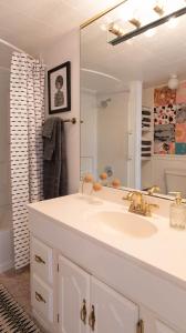 ein Badezimmer mit Waschbecken und großem Spiegel in der Unterkunft Baby Owl Lakehouse in Canyon Lake