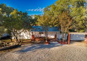 ein Haus mit Bäumen und einer Kieseinfahrt in der Unterkunft Baby Owl Lakehouse in Canyon Lake