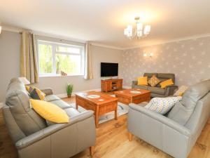 a living room with two couches and a tv at Fallowfield in Great Yarmouth