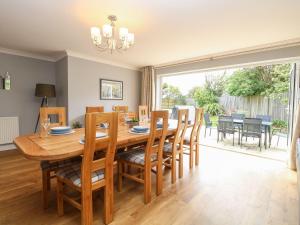 a dining room and living room with a wooden table and chairs at Fallowfield in Great Yarmouth