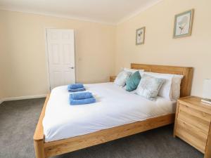 a bedroom with a large bed with blue towels on it at Fallowfield in Great Yarmouth