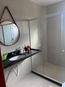 a bathroom with a shower and a sink and a mirror at CASA TOTALMENTE EQUIPADA AMPLA E CONFORTAVEL em CONDOMINIO - CHÃ GRANDE-PE in Chã Grande