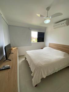 a bedroom with a bed and a desk with a television at CASA TOTALMENTE EQUIPADA AMPLA E CONFORTAVEL em CONDOMINIO - CHÃ GRANDE-PE in Chã Grande