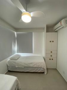 een witte slaapkamer met een bed en een witte kast bij AMPLA E CONFORTAVEL CASA TOTALMENTE EQUIPADA em CONDOMINIO - CHÃ GRANDE-PE in Chã Grande