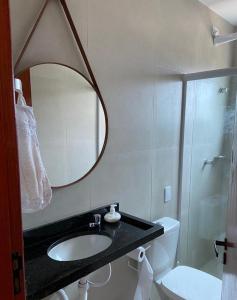 een badkamer met een wastafel, een spiegel en een toilet bij AMPLA E CONFORTAVEL CASA TOTALMENTE EQUIPADA em CONDOMINIO - CHÃ GRANDE-PE in Chã Grande