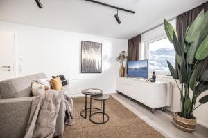 a living room with a couch and a large window at MaxStudio Premium Apartment Zillertal mit Bergblick in Schlitters