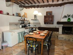 cocina con mesa de madera con sillas y cocina con fogones en Il Fiore di Montieri, en Montieri