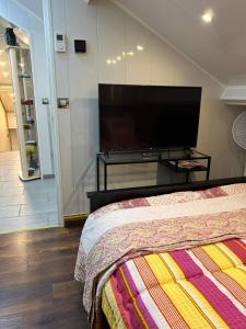 a bedroom with a flat screen tv and a bed at Appartement T LUXE in Pierrefitte-sur-Seine