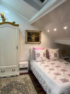 a bedroom with a bed with pink and white pillows at Appartement T LUXE in Pierrefitte-sur-Seine