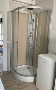 a shower stall in a bathroom next to a refrigerator at Studio tout confort bien situé in Orléans