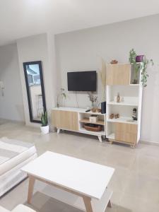 sala de estar con TV y sofá blanco en Jardines del Boulevard 4 en Córdoba