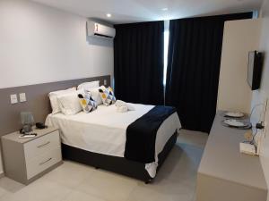 1 dormitorio con 1 cama grande y cortinas negras en Flat América Pelinca Campos en Campos dos Goytacazes