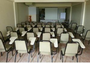 a room with a bunch of chairs and a screen at Hotel Paraiso Belém in Belém