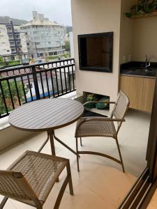 balcón con mesa y 2 sillas en Apto novo a uma quadra da praia, en Florianópolis