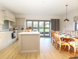 a kitchen and dining room with a table and chairs at Hillside Cottage in Beeston