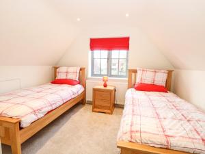 deux lits jumeaux dans une chambre avec fenêtre dans l'établissement Hillside Cottage, à Beeston